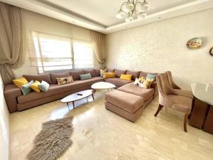 a living room with a couch and a table at Taj nouaceur aéroport Mohamed V in Nouaseur