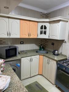 a kitchen with white cabinets and a sink at City Square in Alexandria