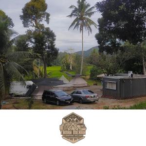 dwa samochody zaparkowane na parkingu z palmą w obiekcie Tanah Merah Glamping Village (TMGV) w mieście Kuala Kangsar