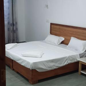 ein Bett mit weißer Bettwäsche und weißen Kissen darauf in der Unterkunft Jade luxury apartments Diani in Mombasa