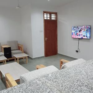 ein Zimmer mit Tischen, Stühlen und einer Tür in der Unterkunft Jade luxury apartments Diani in Mombasa