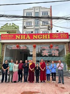 grupa ludzi stojących przed budynkiem w obiekcie Motel Hằng Hiên 