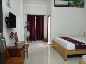 sypialnia z łóżkiem, biurkiem i oknem w obiekcie Motel Hằng Hiên 