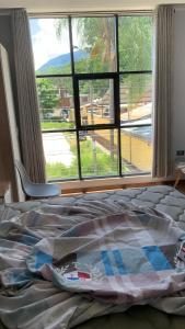 un letto in una camera da letto con una grande finestra di MILANO SUITE a San Ramón