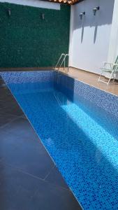 una gran piscina con azulejos azules en el suelo en MILANO SUITE, en San Ramón
