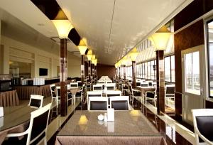 un ristorante con tavoli, sedie e finestre bianche di Gold Hotel a Istanbul