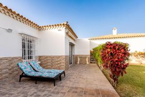 uma cadeira num pátio ao lado de uma casa branca em Bungalow in Golf del sur em San Miguel de Abona