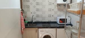 a kitchen with a sink and a washing machine at Casa La Tía Bruja - B in La Alberca
