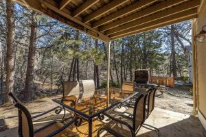 eine Terrasse mit einem Tisch, Stühlen und einem Grill in der Unterkunft Yosemite Bass Lake Adventure Oasis in Bass Lake
