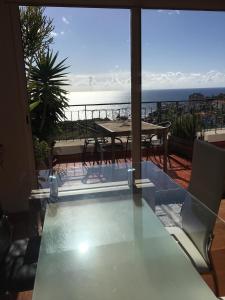 a glass table with a view of the ocean at OceanView Penthouse in Caniço