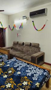 uma sala de estar com um sofá e uma cama em KS Home Stay em Tiruchchendūr