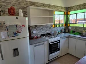 a kitchen with a white refrigerator and a stove at Los Abuelos in Duggan