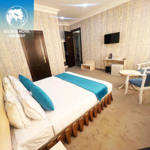 1 cama grande con almohadas azules en una habitación en HOTEL GLOBUS, en Tashkent