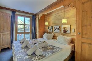 a bedroom with a bed with wooden walls and a window at ARC 1950 - Appartement 5 personnes - ski aux pieds - Sauna, Hammam, Jacuzzi in Arc 1950