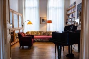 a living room with a couch and a piano at Heaven in Antwerp in Antwerp