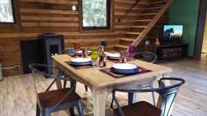 una mesa de madera con platos y copas de vino. en Loft Vintage Bosques del Sur Puerto Varas, en Puerto Varas