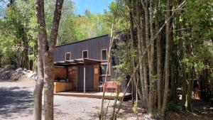 a black house in the middle of the forest at Loft Vintage Bosques del Sur Puerto Varas in Puerto Varas