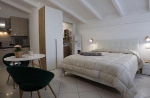 a bedroom with a large bed and a table and a kitchen at La casa dei nonni in San Giuseppe Vesuviano