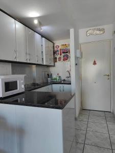 kuchnia z białymi szafkami i białą mikrofalówką w obiekcie Minerva Apartments Sea View w mieście Benalmádena
