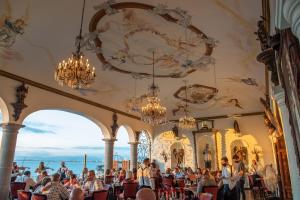 une foule de personnes assises dans une pièce ornée de lustres dans l'établissement BellView Hotel Boutique, à Puerto Vallarta