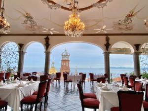 uma sala de jantar com mesas e cadeiras e uma torre do relógio em BellView Hotel Boutique em Puerto Vallarta