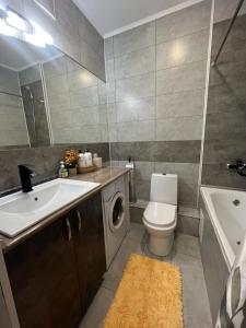 een badkamer met een wastafel en een wasmachine bij Nurly Zhol apartment in Promyshlennyy