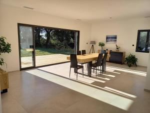 comedor con mesa de madera y sillas en Villa neuve de standing au calme, en Sommières