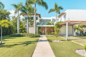 une maison avec des palmiers et une passerelle dans l'établissement Luxurious and modern Villa with Pool at Yarari, à Punta Cana