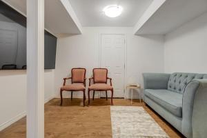 a living room with two chairs and a couch at Comfortable Whitby 2 Bedroom Lower Suite in Whitby