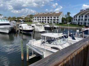 a group of boats docked at a marina with a hotel at Harbor View, short 7 minute walk to beach. in Vero Beach