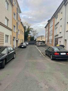 parking z zaparkowanymi samochodami i budynkami w obiekcie Moderne City Wohnung Paderborn Zentrum w mieście Paderborn