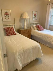 a bedroom with two beds and a table with a lamp at Harbor View, short 7 minute walk to beach. in Vero Beach