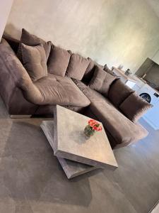 a brown couch in a living room with a table at Moderne City Wohnung Paderborn Zentrum in Paderborn
