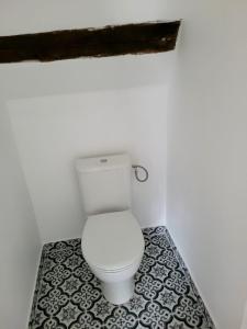 baño con aseo blanco y suelo de baldosa blanco y negro en Appartement atypique, en Mitry-Mory