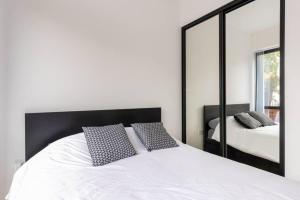 een slaapkamer met een wit bed en een grote spiegel bij Gorgeous, Modern apartment-fantastic location in Slough