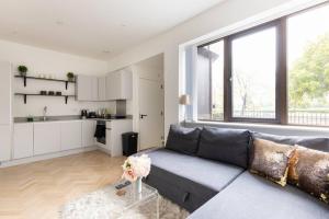 a living room with a couch and a kitchen at Gorgeous, Modern apartment-fantastic location in Slough