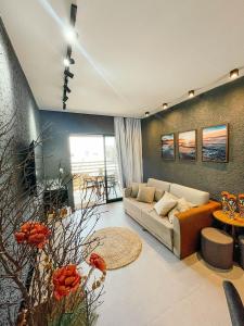 un salon avec un canapé et une table dans l'établissement Excelente condomínio com uma belíssima área de lazer próximo à praia do Patacho, à Porto de Pedras