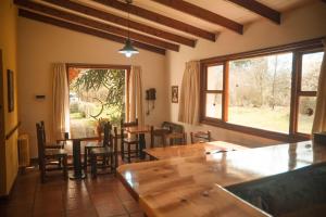 a dining room with tables and chairs and a large window at Huala Hosteria in Lago Puelo