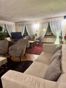 a living room with a couch and chairs and a table at Hotel Zeni in Madonna di Campiglio