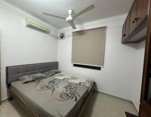 - une chambre avec un lit et un ventilateur de plafond dans l'établissement Muar 6 Bedrooms Semi-D With Security Guard Homestay 15-20pax, à Muar