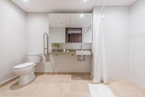 a white bathroom with a toilet and a sink at El Tesoro Medellín Hab310 by Letoh in Medellín