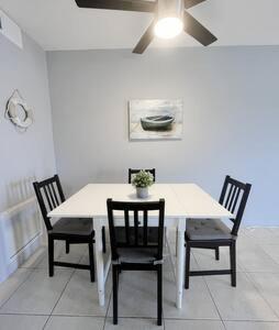 a dining room table with two chairs and a white table at Charming Beach Condo located in Amazing Location! in St. Pete Beach