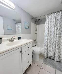 a bathroom with a sink and a toilet and a shower curtain at Charming Beach Condo located in Amazing Location! in St. Pete Beach