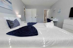 a large white bed with a blue blanket on it at Perfect Beach Getaway with Dock AND Pet Friendly in St Pete Beach