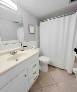 a white bathroom with a sink and a toilet at Beautiful Madeira Beach 1 Bed Condo With Boat Dock in St Pete Beach
