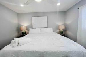 a bedroom with a large white bed with two lamps at Beautiful Madeira Beach 1 Bed Condo With Boat Dock in St Pete Beach