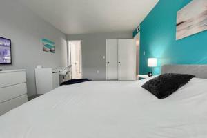 a bedroom with a large white bed with a blue wall at Madeira Beach 2 bedroom Waterfront Condo With Dock in St Pete Beach