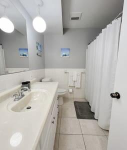 a white bathroom with a sink and a mirror at Madeira Beach 2 bedroom Waterfront Condo With Dock in St. Pete Beach