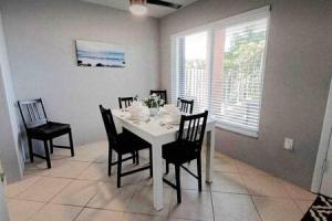 a dining room with a white table and chairs at 2x1 Beach Condo! Walk to the Beach AND Restaurants! in St Pete Beach