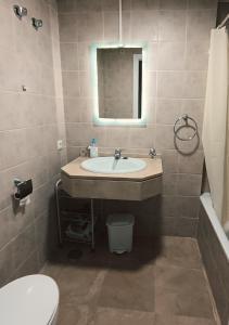a bathroom with a sink and a toilet and a mirror at Bella Vista Casares in Bahia de Casares
